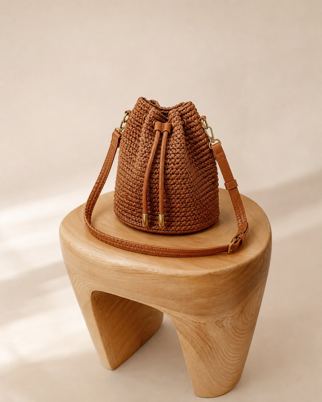 Bolsa bucket Serra em tom conhaque sobre banco de madeira